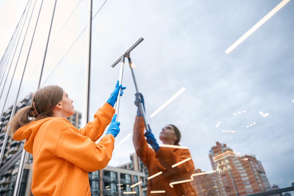 A woman cleaning the window of a building